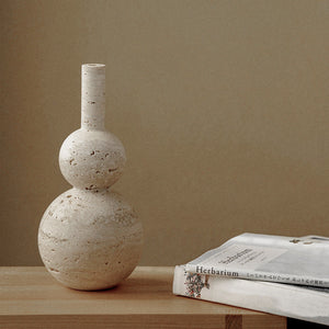 Travertine Stone Vase Gourd shape with book and magazine Herbarium in japanese on a beech wood table with olive wall backdrop